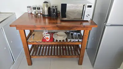 a small wooden table in a kitchen with a microwave at Nemesia Suites in Cape Town