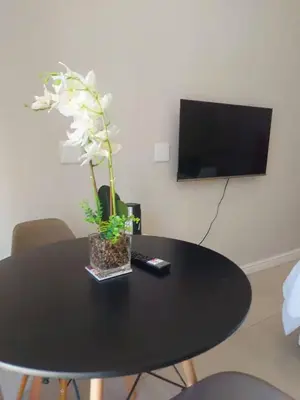 a black table with a vase with white flowers on it at Nemesia Suites in Cape Town