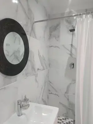 a white bathroom with a sink and a mirror at Nemesia Suites in Cape Town