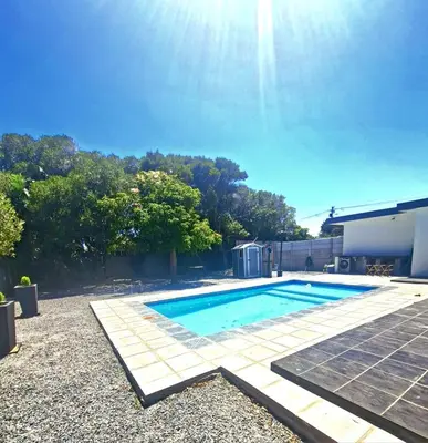 a swimming pool in the yard of a house at Nemesia Suites in Cape Town