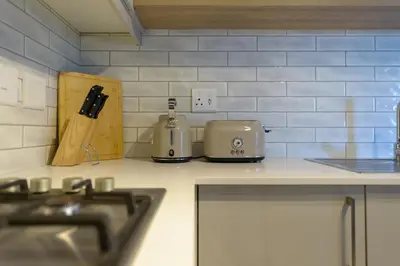 a kitchen with a counter top with a stove top at Nua Chic Stylish 1Bedroom - 2mins to Beach in Cape Town