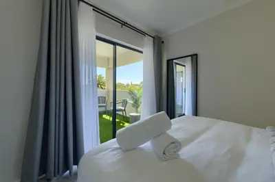 a bedroom with a bed and a window with a view at Nua Chic Stylish 1Bedroom - 2mins to Beach in Cape Town