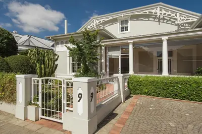 a white house with a gate in front of it at Story Haus in Stellenbosch