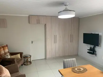 a living room with a couch and a table at Entire large 1 bedroom very private with parking in Cape Town