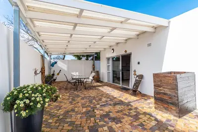a patio with awning and a table and chairs at Entire large 1 bedroom very private with parking in Cape Town