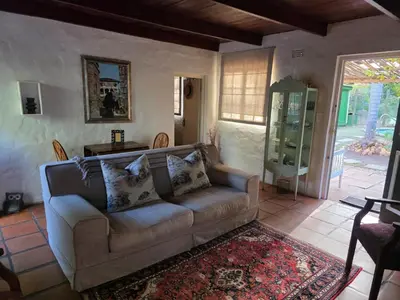 a living room with a couch and a table at Maggie Rose Self Catering Cottage in Greyton