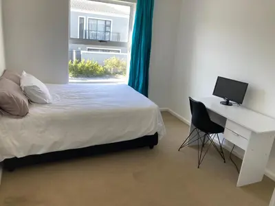a bedroom with a bed and a desk with a computer at Polaris House in Cape Town