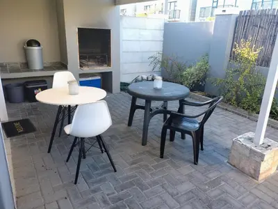 two tables and chairs sitting on a patio at Polaris House in Cape Town