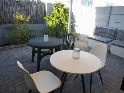 two tables and chairs sitting on a patio at Polaris House in Cape Town