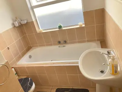 a bathroom with a tub and a sink and a toilet at Polaris House in Cape Town