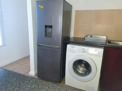 a kitchen with a washing machine and a refrigerator at Polaris House in Cape Town