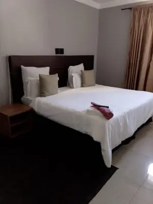 a bedroom with a large bed with white sheets and pillows at Edion Royal Guesthouse in Cape Town