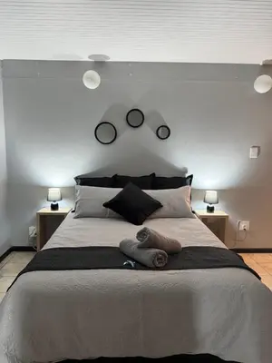 a bedroom with a large bed with three mirrors on the wall at Worcester Cozy Stay - Apto 1 in Worcester