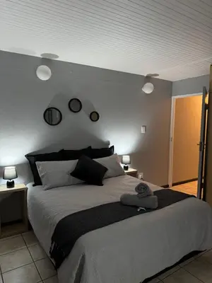 a bedroom with a large bed with two lights on the wall at Worcester Cozy Stay - Apto 1 in Worcester