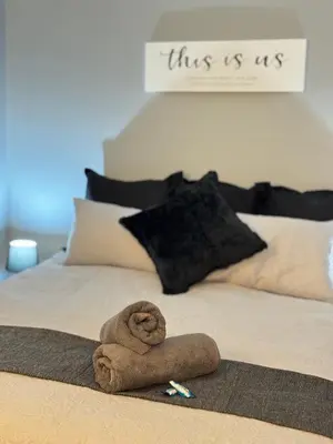 a bed with a rolled up towel on top of it at Worcester Cozy Stay - Apto 1 in Worcester