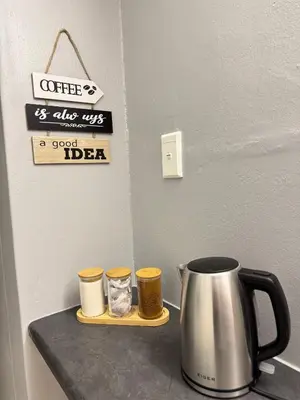 a tea kettle and three cups on a counter at Worcester Cozy Stay - Apto 1 in Worcester