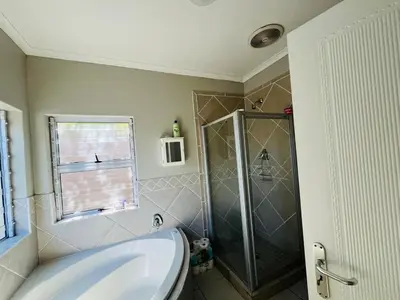a bathroom with a shower and a white tub at 4 Bedroom Bliss in Cape Town