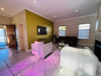 a living room with two chairs and a tv at 4 Bedroom Bliss in Cape Town