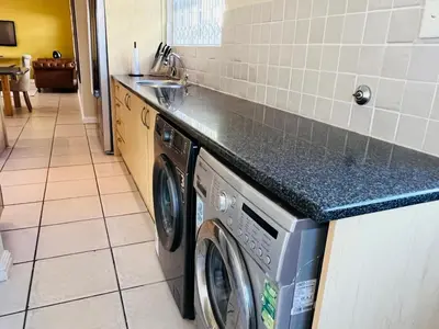 a kitchen with a washing machine and a counter at 4 Bedroom Bliss in Cape Town
