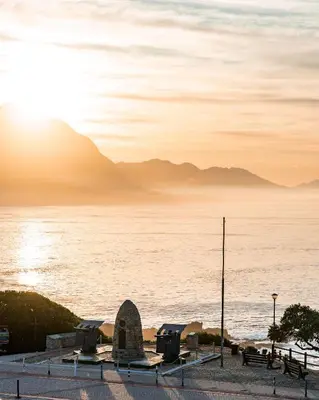 a view of the ocean with mountains in the background at Harbour House Hotel in Hermanus