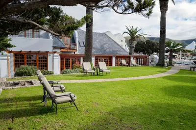 a group of chairs sitting in the grass in front of a house at Harbour House Hotel in Hermanus
