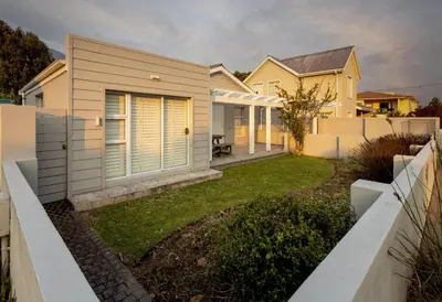 a house with a fence and a yard at Silencio in Hermanus