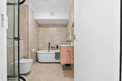 a bathroom with a tub and a toilet and a sink at Modern Luxury 2BR Island Club Century City in Cape Town