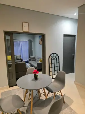 a living room with a table and chairs at Rachel`s Apartments - Stepney Crescent in Cape Town