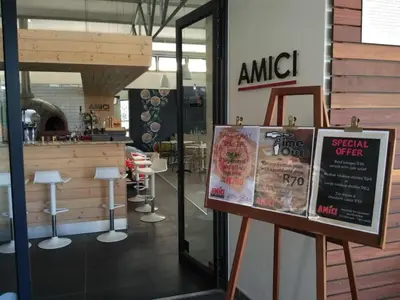 a restaurant with a sign in front of a store at Cape Town Apartment with Table Mountain View in Cape Town