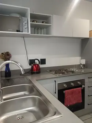 a kitchen with a sink and a stove top oven at Belhar Lofts in Belhar