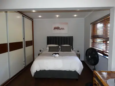 a bedroom with a bed and a fan in it at African Oasis Kenya in Somerset West