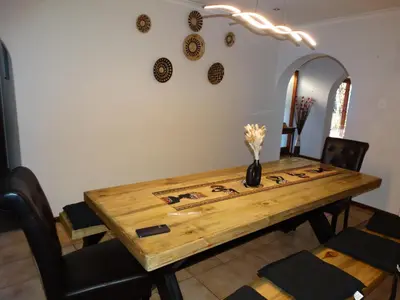 a dining room table with a vase of flowers on it at African Oasis Kenya in Somerset West