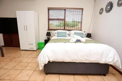 a bedroom with a large bed with two teddy bears on it at African Oasis Zambia in Somerset West