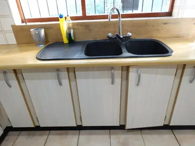 a kitchen counter with a sink and a window at African Oasis Zambia in Somerset West