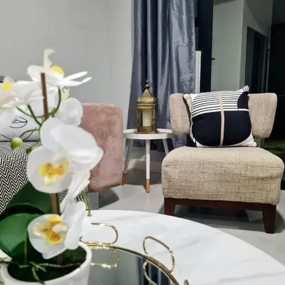a living room with a couch and a table with white flowers at Cosy Apartment at Sitari Country Estate - Somerset West in Croydon