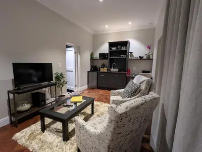 a living room with two chairs and a coffee table at Fifty9 in Somerset West