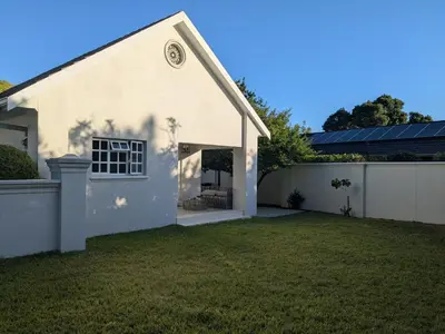 a white house with a yard and a fence at Fifty9 in Somerset West