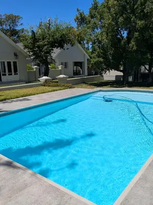 a large blue swimming pool in front of a house at Fifty9 in Somerset West