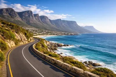 an empty road next to the ocean and mountains at Atlantic Lorea hight Tea in Cape Town