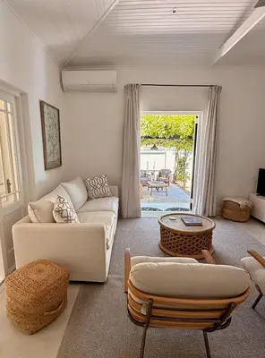 a living room with a couch and a table at Elevené - one bedroom cottage with private pool in Franschhoek