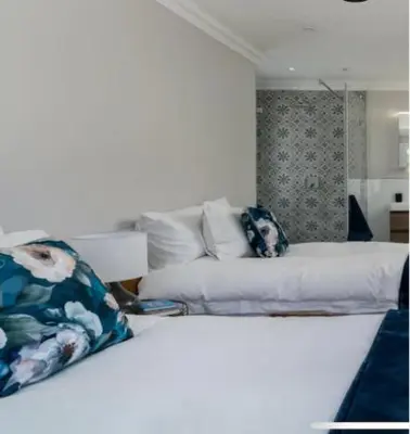 a white bed with pillows on it in a room at Sues Suite in Somerset West
