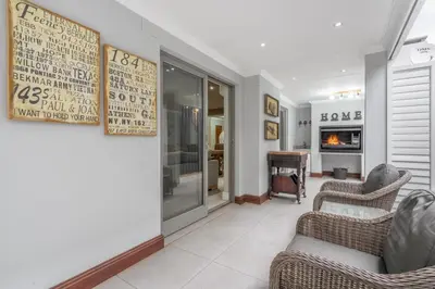 a living room with two chairs and a fireplace at Avemore Lagratitude no6 - with full backup power in Stellenbosch