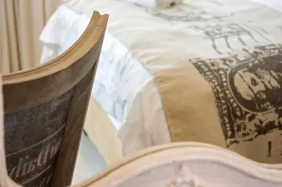 a wooden chair sitting in front of a bed at Avemore Lagratitude no6 - with full backup power in Stellenbosch