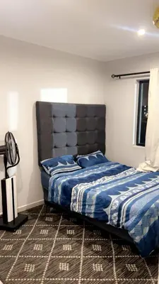 a bedroom with a bed with a blue comforter at Smart and elegant space in Cape Town