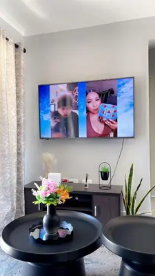 a living room with a table and a tv at Smart and elegant space in Cape Town