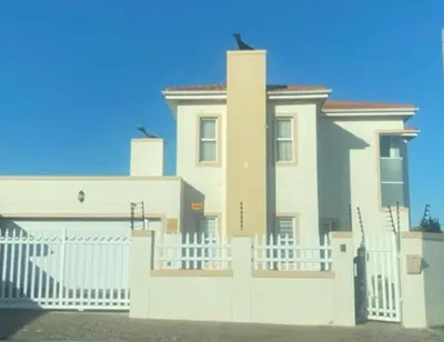 a large white house with a white fence at KwaNolz in Cape Town