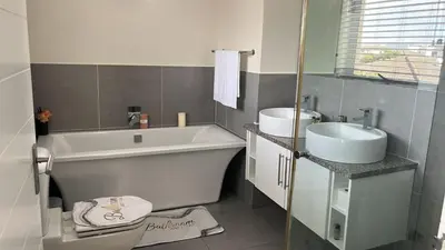 a bathroom with a tub and a sink and a toilet at KwaNolz in Cape Town
