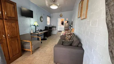 a living room with a couch and a wall at Sea Breeze in Strand