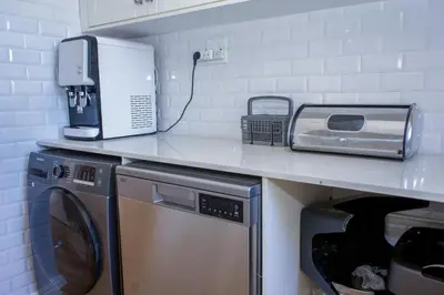 a kitchen with a washer and dryer on a counter at 5BR Pool Fast Wi-Fi Walk To The Beach Pool Table in Cape Town