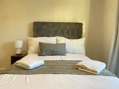 a bed with two towels on top of it at Elegant, Relaxing Gateway House in Cape Town in Cape Town